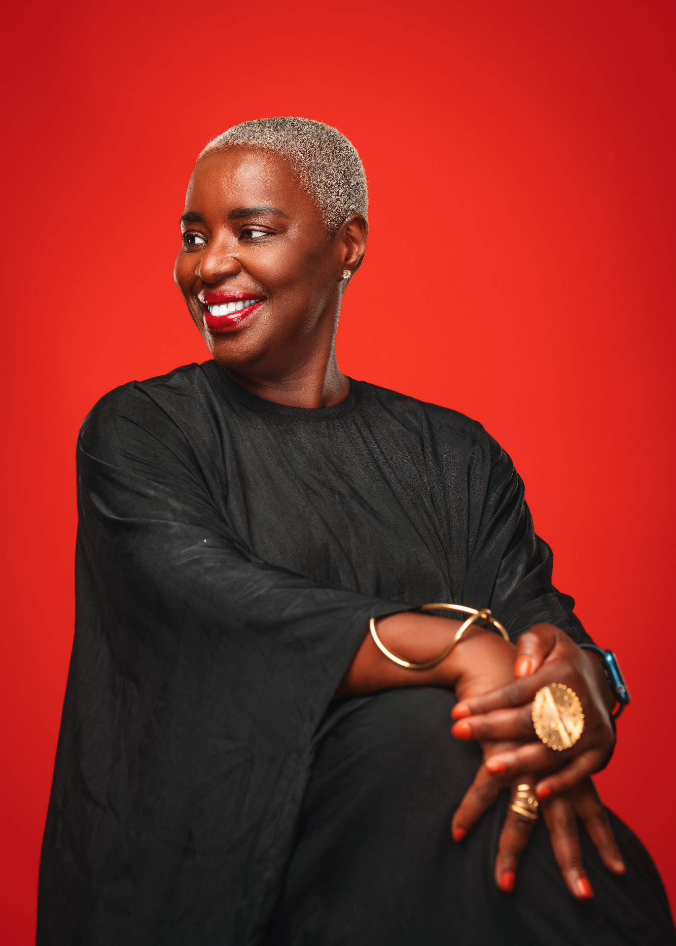 Aja, founder of Lingeer, smiling warmly against a vivid red backdrop